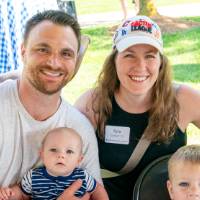 Kyla Currie '13 posing for a picture with husband and two sons